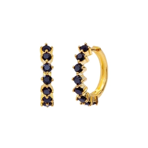 Detail of gold huggie earrings with black cubic zirconia stones on white background