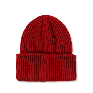 Close-up of deep red ribbed knit beanie showing thick texture and folded brim detail