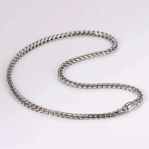 Macro shot of silver stainless steel braided chain necklace with polished metal link detail