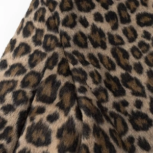 Close-up of leopard print faux fur fabric showing dense brown and black fibers