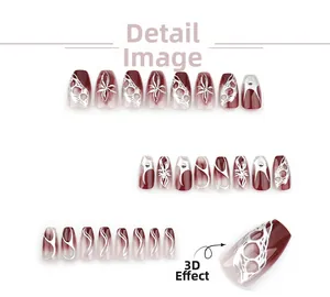 Close-up of burgundy gradient press-on nails with 3D silver metallic textures and beads