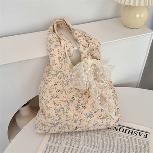 Detail of floral canvas bag with white lace bow decoration and vintage flower patterns