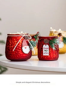 Close-up of red frosted glass Christmas jars with LED lights and festive pine decorations