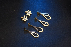 Detailed view of four pairs of elegant gold-tone earrings with pearls and teardrop pendants