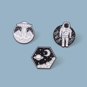 Three minimalist black and white astronaut series enamel pins on a light blue background