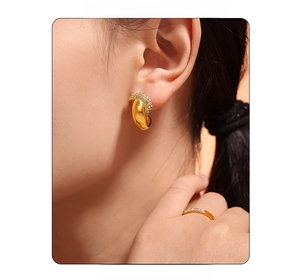 Macro view of gold plated titanium steel crescent earrings and ring with zircon inlay