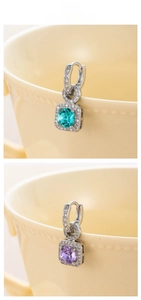 Detailed close-up of sparkling cubic zirconia earrings in blue and lavender purple colors