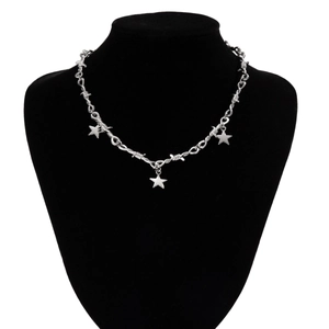 Detail of silver thorn chain necklace with three pentagram star pendants on a model