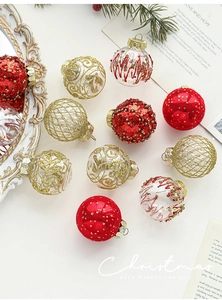 Detail of red and gold Christmas ornaments with glitter and sequins on white background