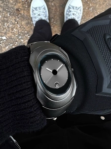 Close-up of minimalist futuristic Y2K men's quartz watch with sleek dark grey metal case