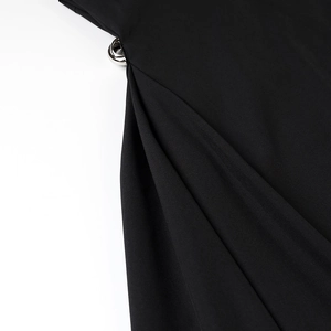 Detail showing silver metal buckle and pleated fabric of the slim fit black dress