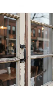 Close-up of vintage cast iron drawer handle mounted on a rustic wood cabinet door