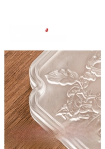 Detail of crystal glass tea tray with frosted leaf relief and wavy edge design