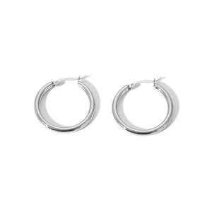 Détail macro des boucles d'oreilles créoles en acier inoxydable poli à finition lisse