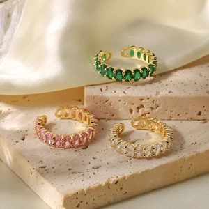 Detailed view of three 18k gold plated adjustable rings with emerald, pink, and white zircons