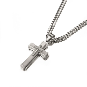 Macro detail of silver stainless steel layered cross pendant with sparkling zircons