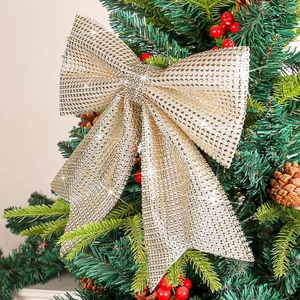 Sparkly gold mesh Christmas bow with glitter on a festive tree background