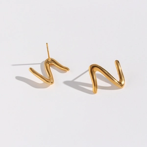 Macro shot of minimalist gold wave Z-shape earrings with polished metallic surface
