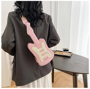 Detail of pink and white guitar shaped crossbody bag with silver star and metal studs