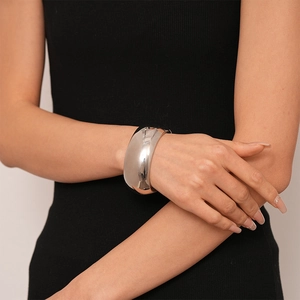 Polished silver wide irregular geometric open cuff bracelet on a model wrist