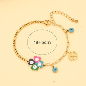Detailed view of evil eye and clover charms on a gold bracelet with 18+5cm size label