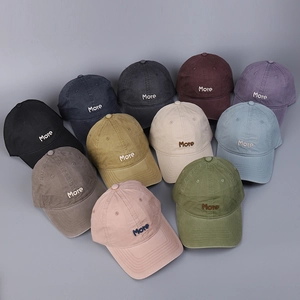 Flat lay showing 11 colors of cotton baseball caps with More letter embroidery