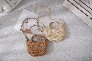 Detail von gewebten Strohtaschen in Beige und Karamell mit Rundgriffen und Riemen