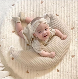 Detailed close-up of quilted cotton moon nursing pillow with matching beige play mat