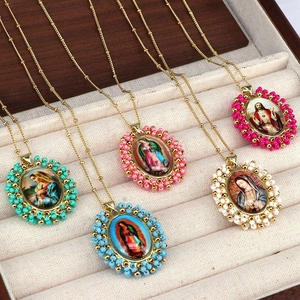 Close-up of religious portrait pendants with colorful beads on gold bead chains