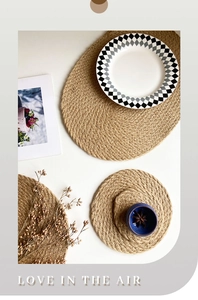 Flat lay of round jute placemats and coasters with rustic woven texture on white background