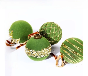 Close-up of green flocked Christmas ornaments with gold sequins and beaded details