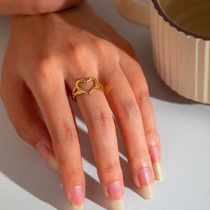Macro shot of gold-plated stainless steel heart ring worn on a finger for detail