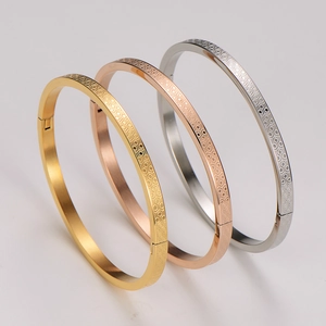 Dettaglio di tre bracciali in acciaio inossidabile con motivo esagonale a nido d'ape