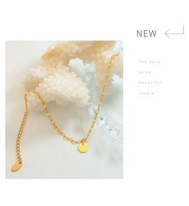 Detail shot of K18 hallmark on elegant 18k gold-plated geometric disc charm bracelet