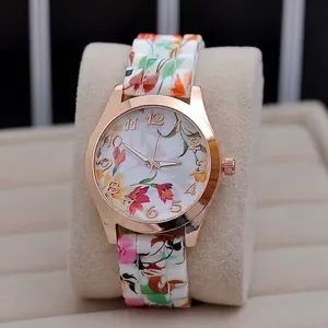 Detail of rose gold watch case with floral dial and matching printed links strap