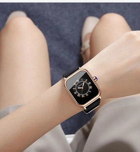 Detailed view of women's square quartz watch with rose gold case and black silicone strap