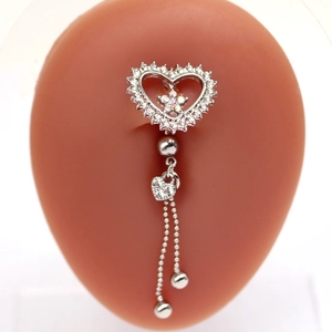Detail of silver heart belly ring with dangling chains and rhinestones on a model