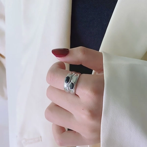 Double-layer silver band ring with two oval black stones worn on a hand