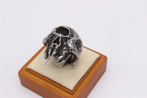 Macro side view of vintage silver-tone skull ring with oxidized punk gothic details