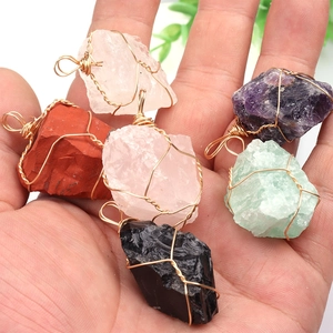 Natural crystal necklaces with wire wrapped irregular stones held in a palm