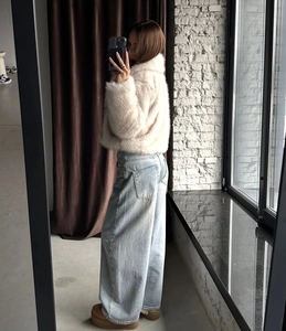 Close-up of fluffy faux fox fur coat texture with wide-leg jeans and platform shoes