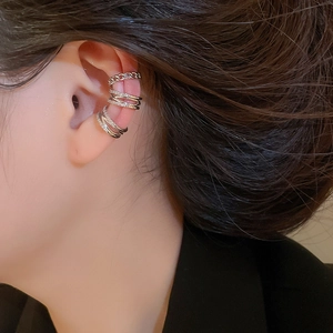Detailed close-up of three silver-toned ear bone clips with sparkling zircon stones