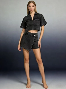 Detail of dark grey washed denim set featuring a V-neck top and asymmetric skirt-pants