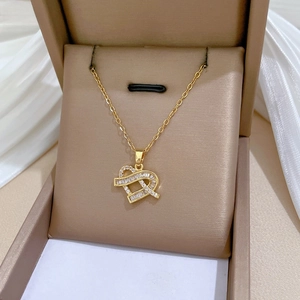 Detailed view of heart-shaped gold necklace with sparkling zircon stones in a jewelry box