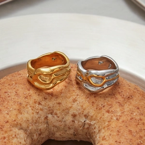 Irregular lava texture 18K gold and silver rings displayed on a creative bread backdrop