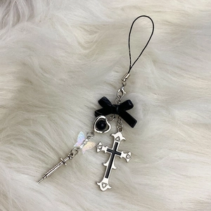 Gothic Y2K phone charm with black bow, cross, and heart on white faux fur background
