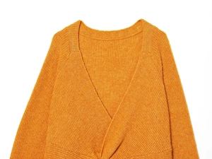 Close-up of mustard yellow knit sweater featuring V-neck and ribbed texture detail