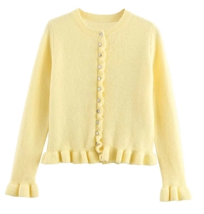 Détail du cardigan en maille jaune avec col rond et bordures à volants sur l'ourlet