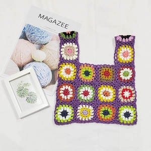 Detailed close-up of handmade crochet tote bag featuring colorful floral patchwork patterns