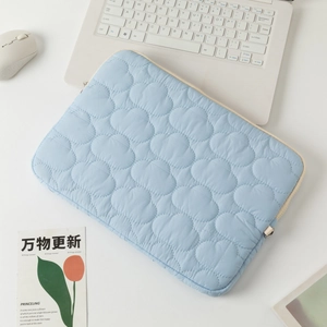 Close-up of quilted light blue laptop sleeve with cloud pattern and premium metal zipper